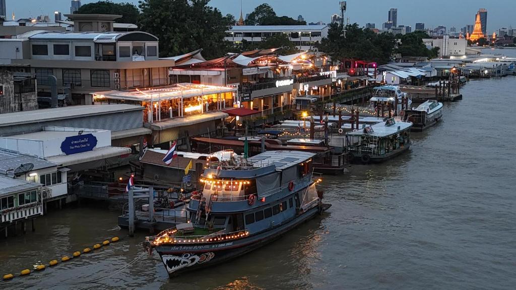 a group of boats docked at a dock in the water at Sabai Sabai Liveaboard Bangkok in Bangkok