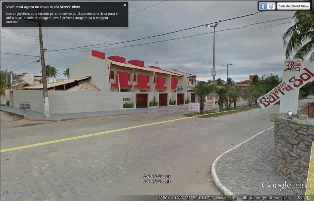 una calle vacía en un pueblo con una señal de stop en Apartamentos Porto Cal, en Barra de São Miguel