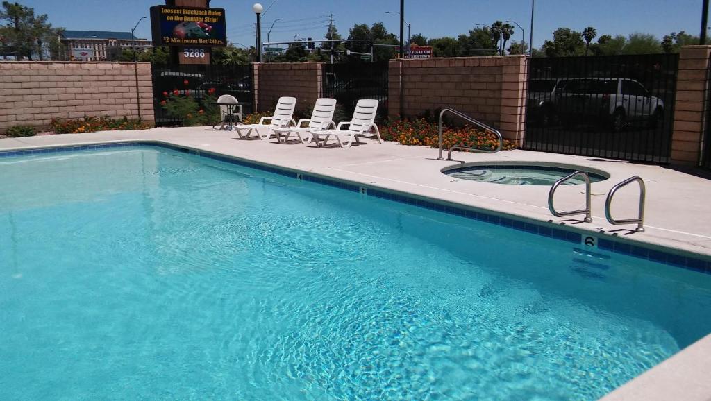 a swimming pool with lounge chairs and a swimming pool at Longhorn Boulder Highway in Las Vegas