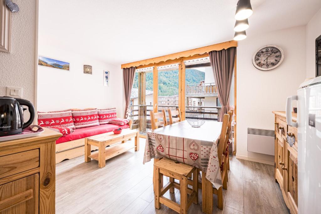 a kitchen and living room with a table and a couch at Les chalets de la vanoise n°4208 in Villarodin-Bourget