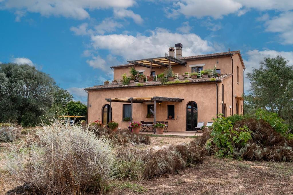 an old house with plants on the roof at Casale Poggio Rocco in Manciano