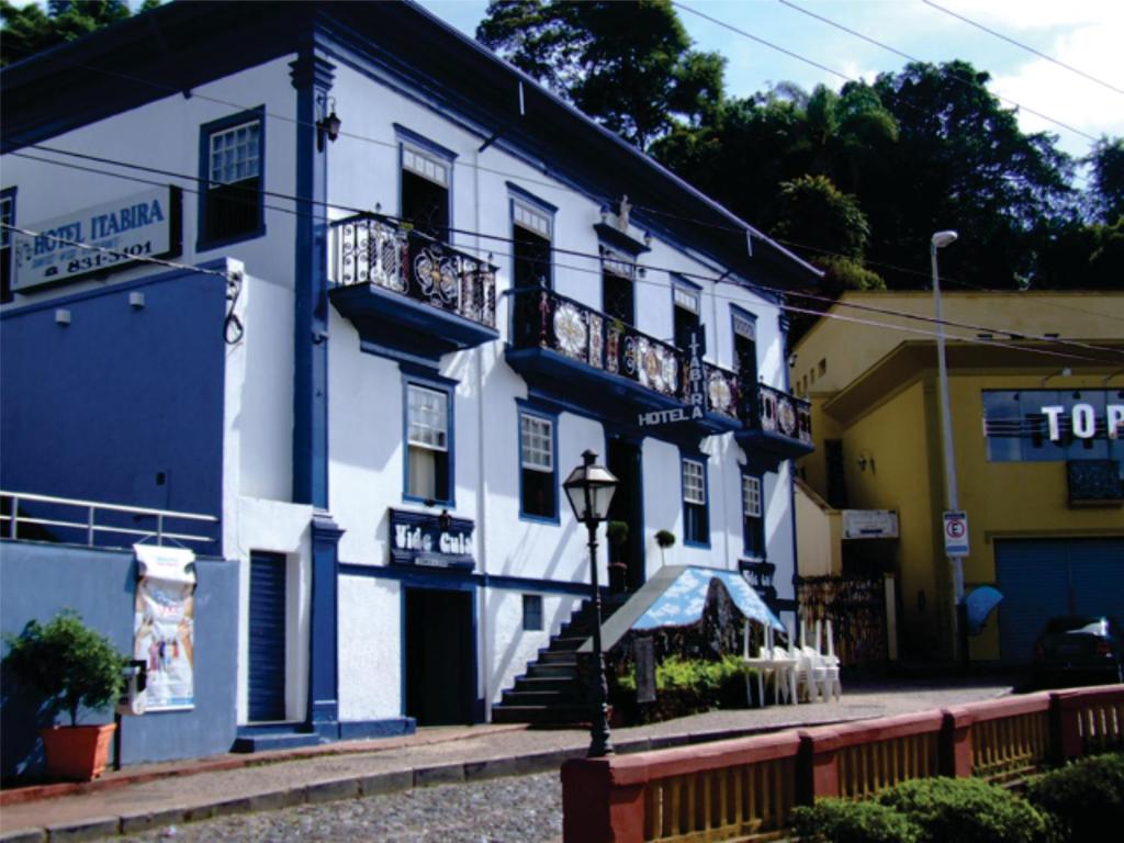 um edifício azul e branco com escadas e varandas em Hotel Itabira em Itabira