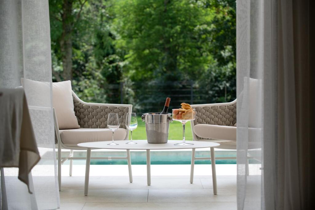 een tafel met wijnglazen en een emmer op een terras bij Villa Castanea s bazenom, jacuzzijem, saunom in Heki