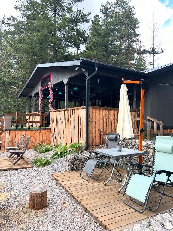a patio with a table and chairs and a building at Quattro Malyovitsa- Мальовица in Govedartsi