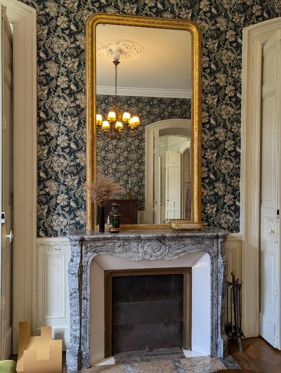 a mirror over a fireplace in a living room at Domaine du Faure in Chadurie