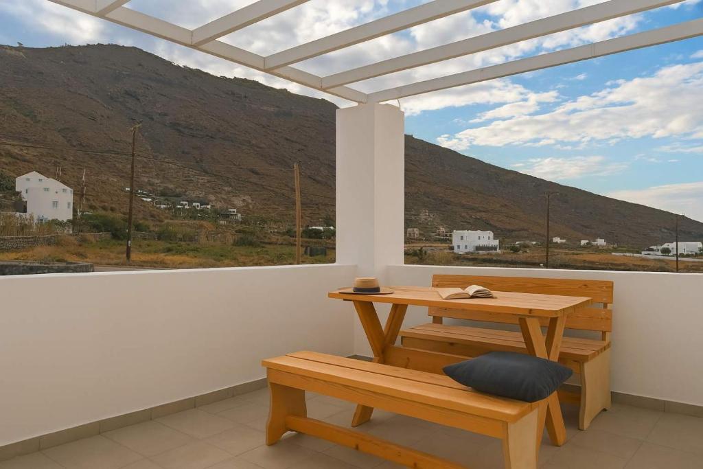 a table and bench in a room with a window at Santorini's Old Mill Serene Getaway by Pori Beach in Vourvoulos