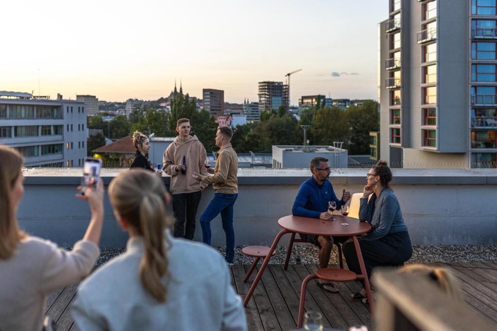 a group of people sitting around a table on a roof at Domeq in Komárov