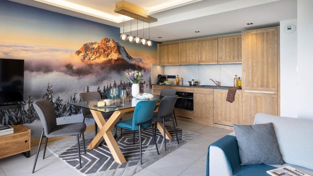 une cuisine et une salle à manger avec une fresque murale représentant la montagne. dans l'établissement MGM Hôtels & Résidences - Résidence Manaka, à Aime La Plagne