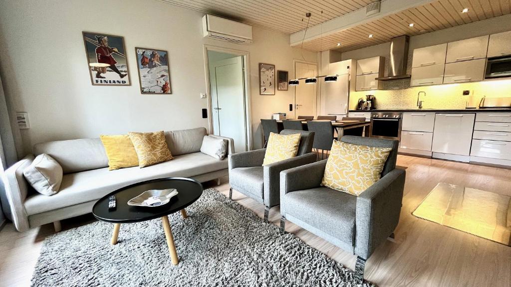een woonkamer met een bank, stoelen en een tafel bij Vuokatti Weekend Piste in Vuokatti