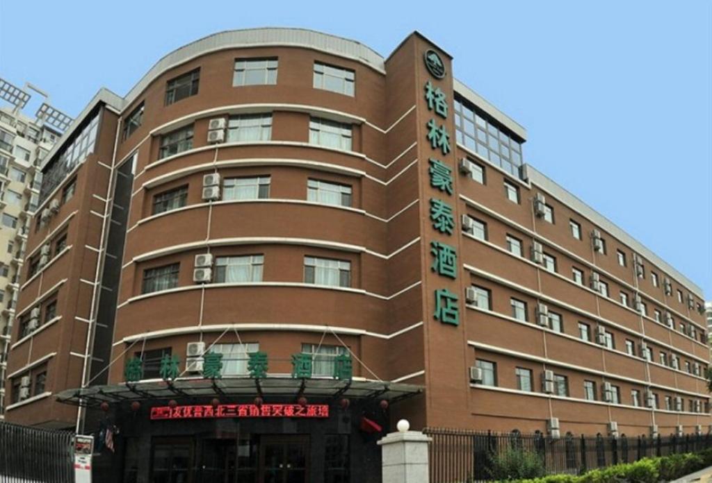 duży brązowy budynek z napisem w obiekcie GreenTree Inn Gansu Lanzhou Yantan High-tech Zone Nanhe Road Business Hotel w mieście Lanzhou