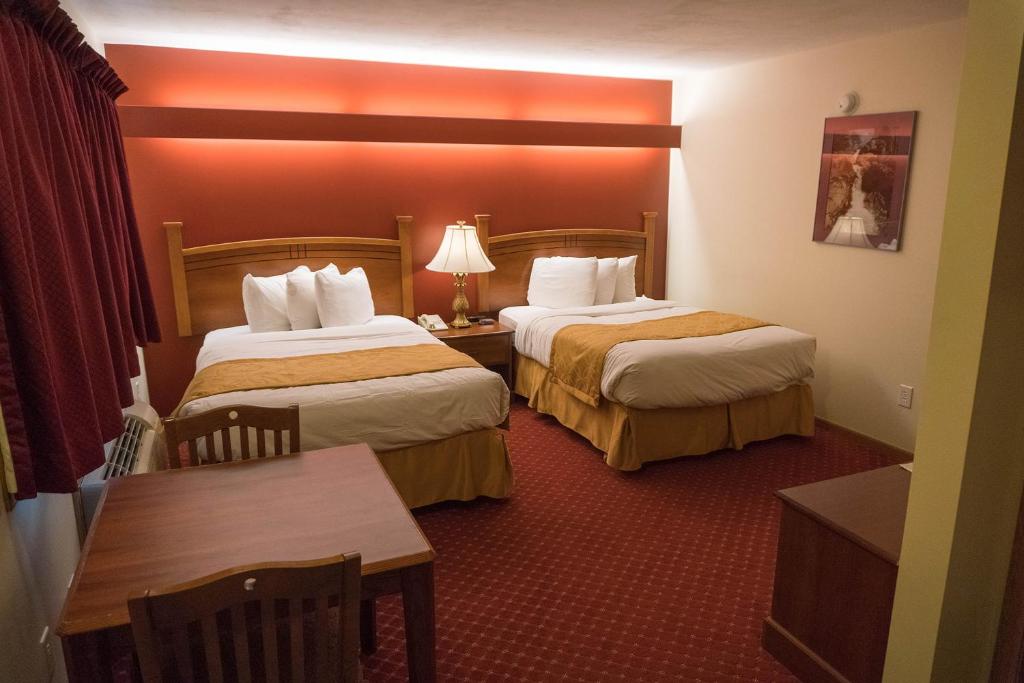 A bed or beds in a room at Shepherd Mountain Inn & Suites