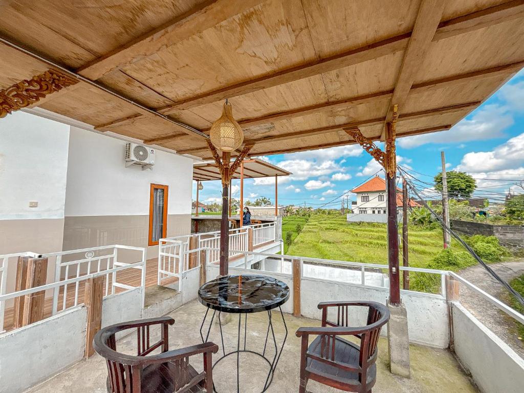a balcony with a table and chairs and a view at Vins Family Homestay in Tumbak Bayuh