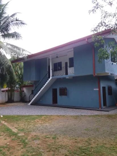 a blue and white building with a staircase on it at LAKROinn in Matugama