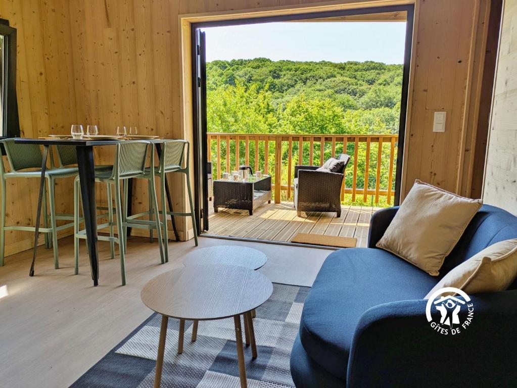 a living room with a couch and a table at Chalet 26 Le Berthevin, Camping de Coupeau, 4 personnes in Saint-Berthevin