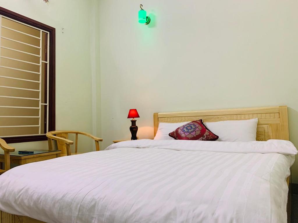 a bedroom with a white bed with a red lamp at Tùng Long Hotel in Thanh Hóa