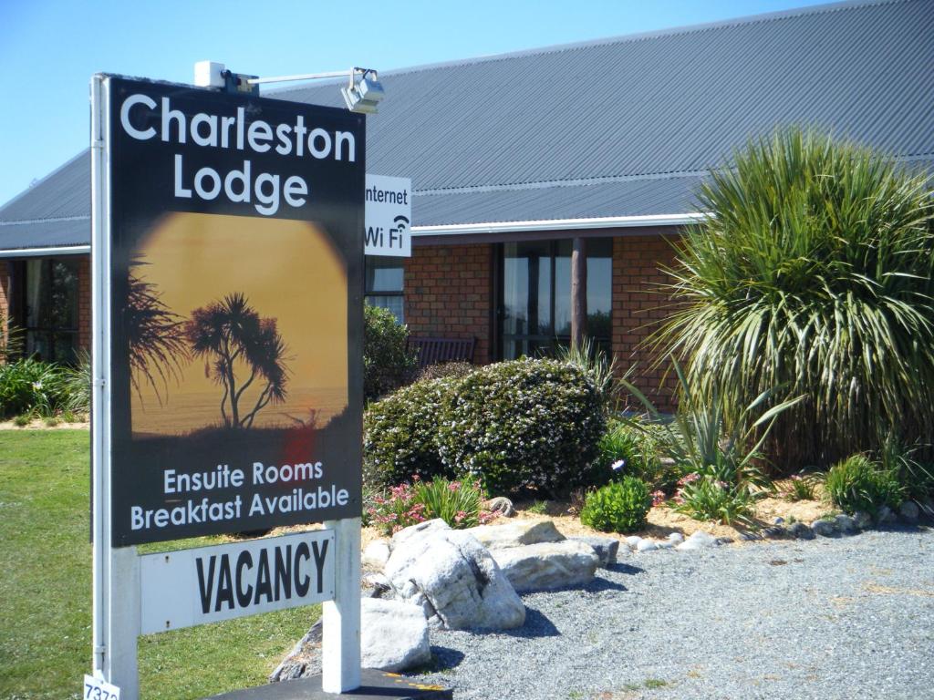 una señal frente a un edificio con un edificio en Charleston Lodge en Charleston