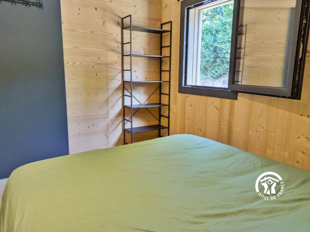 a bedroom with a bed and a book shelf at Chalet 23 Le Moulin, Camping de Coupeau, 4 personnes in Saint-Berthevin