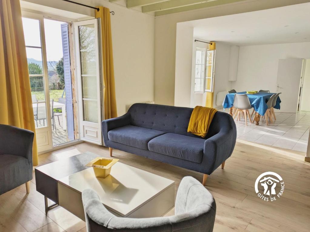 ein Wohnzimmer mit einem blauen Sofa und einem Tisch in der Unterkunft La Musette, jusqu'à 7 pers in Hambers