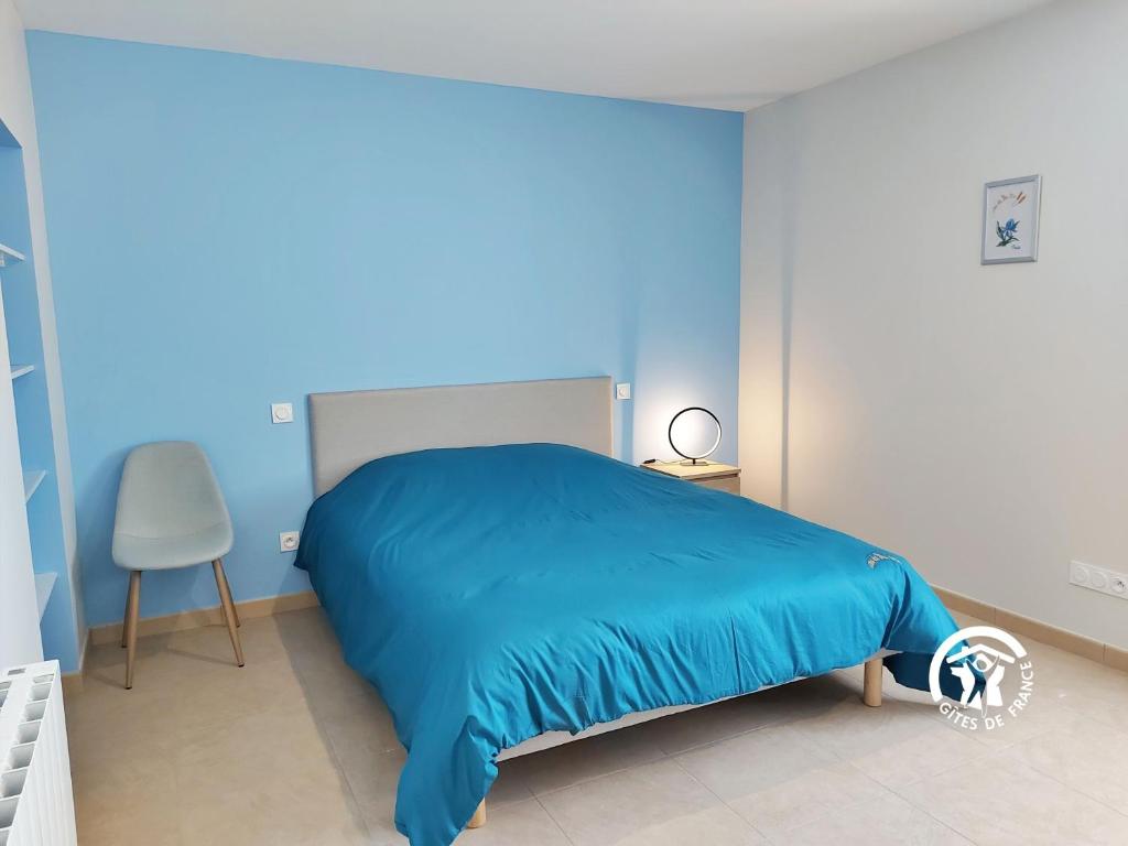 una camera blu con un letto e una sedia di Les Grands Blés d'Or, 12 personnes a Saint-Aubin-du-Désert