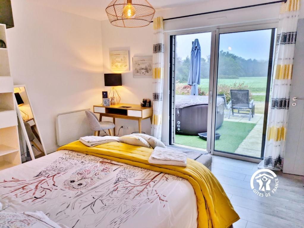 une chambre avec un lit et une vue sur un jardin dans l'établissement La Lande du Pont, à Hambers