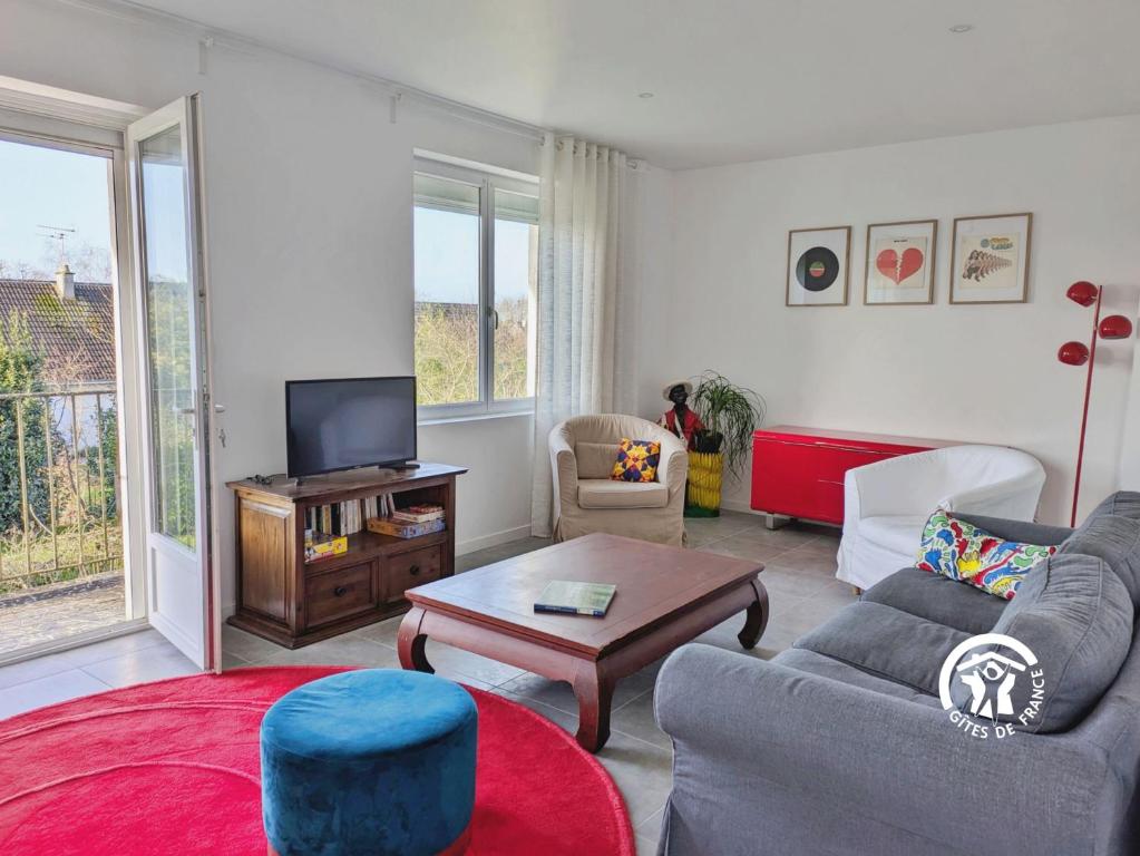 een woonkamer met een bank en een tv bij La maison de Sainte Suzanne, 5 pers in Sainte-Suzanne