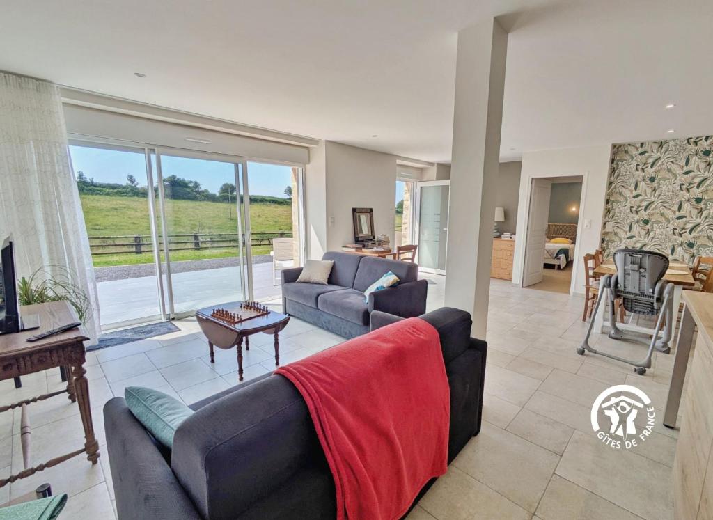 ein Wohnzimmer mit Sofa und Tisch in der Unterkunft Gîte la Maillardière, 2 personnes in Crennes-sur-Fraubée