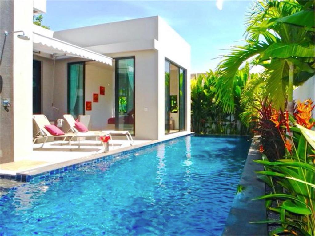 a swimming pool in front of a villa at Baan Bua Nai Harn 3 bedrooms Villa in Nai Harn Beach