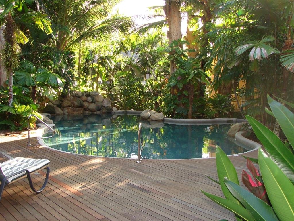 uma piscina no meio de um jardim em Palm Cove Tropic Apartments em Palm Cove