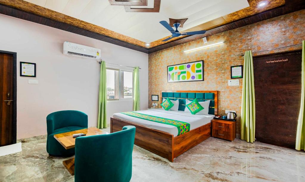 a bedroom with a bed and a table and chairs at Treebo Ramayan Suites Ayodhya in Ayodhya