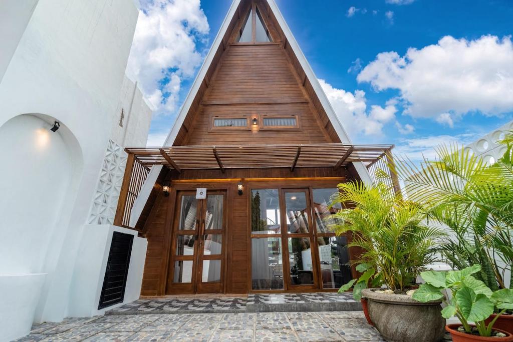 a wooden house with a pointed roof at Alamora Villa - New Stylish 1BR Villa, Canggu in Dalung
