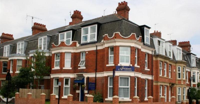 un gran edificio de ladrillo rojo con techo negro en The Avenue Bed and Breakfast en Newcastle