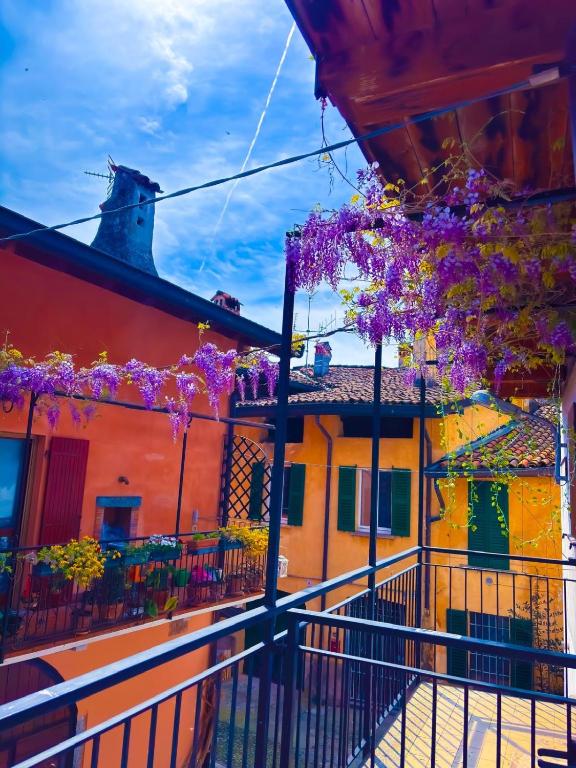 a street with purple flowers hanging from buildings at Casa LuJho in Brivio
