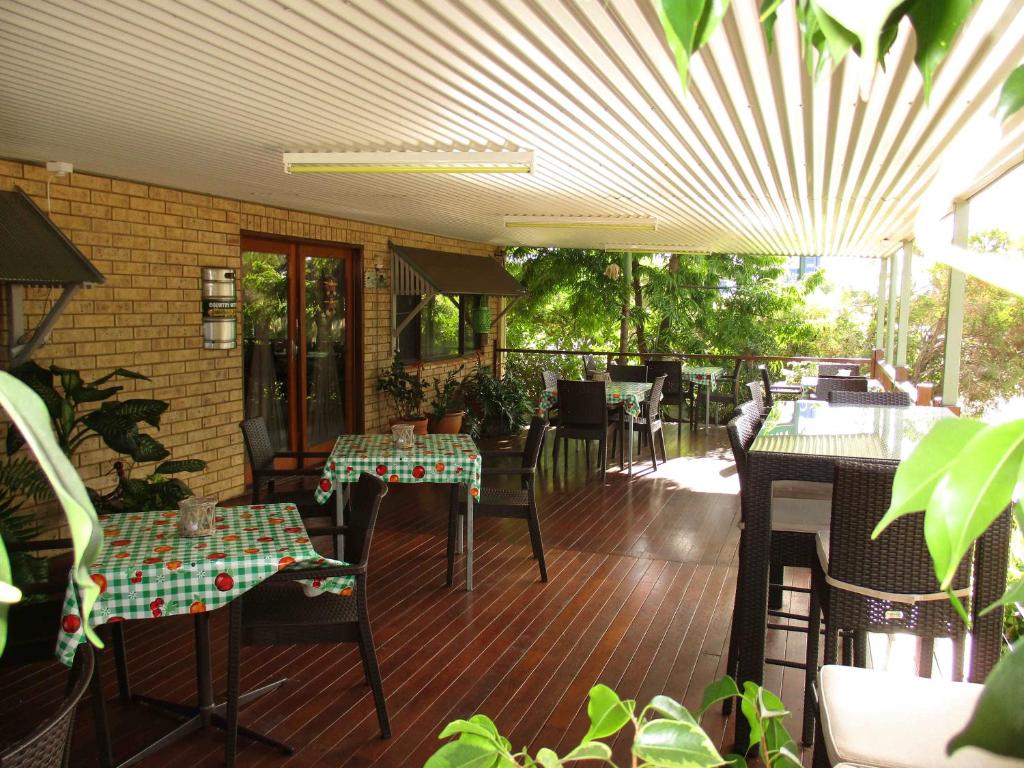 ein Restaurant mit Tischen und Stühlen auf einer Terrasse in der Unterkunft Barcaldine Country Motor Inn in Barcaldine