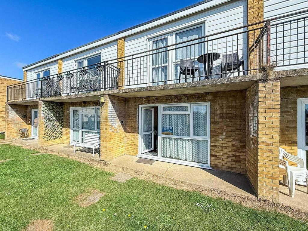 a brick house with a balcony on top of it at 5 Berth Chalet To Hire In Hemsby Near Hemsby Beach Ref 18117B in Hemsby