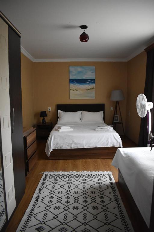 a bedroom with a large white bed and a rug at Mtskheta Apartment 158 in Mtskheta