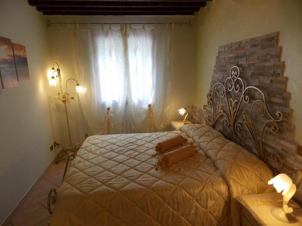 sypialnia z dużym łóżkiem i oknem w obiekcie Il Nido Rustico w mieście Ponsacco