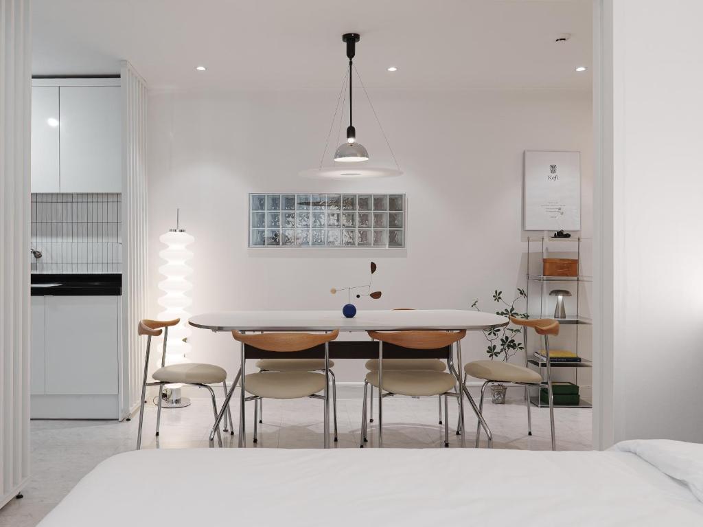 cocina blanca con mesa y sillas en Kefi, en Seúl
