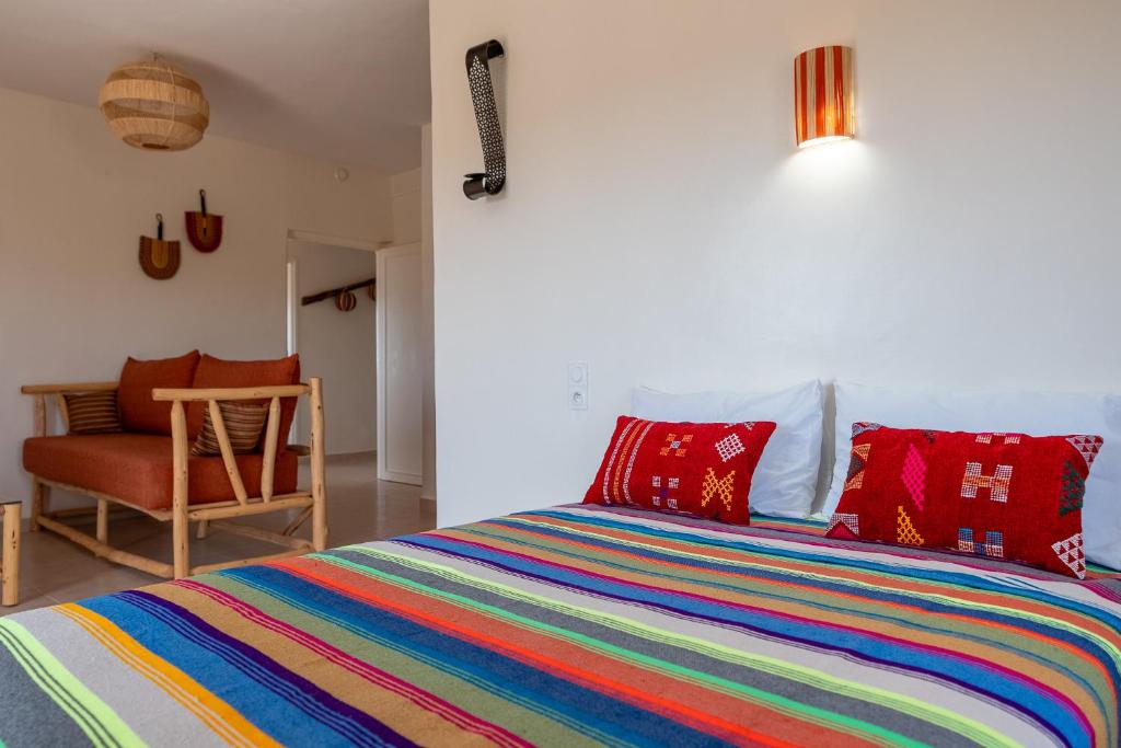 a bedroom with a colorful bed and a chair at Kaouki Zen Lodge in Essaouira