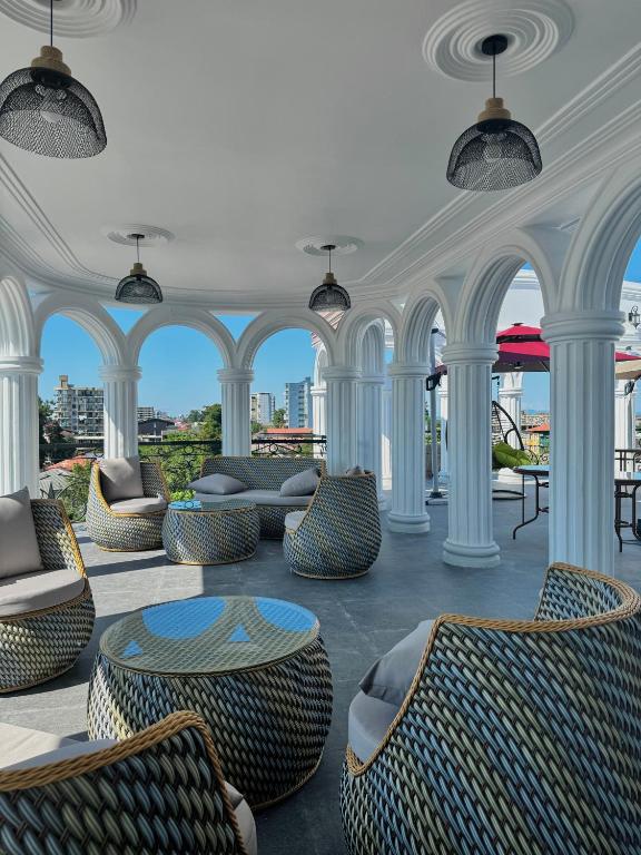 a room with chairs and tables and arches at Hotel Black Sea Kobuleti in Kobuleti
