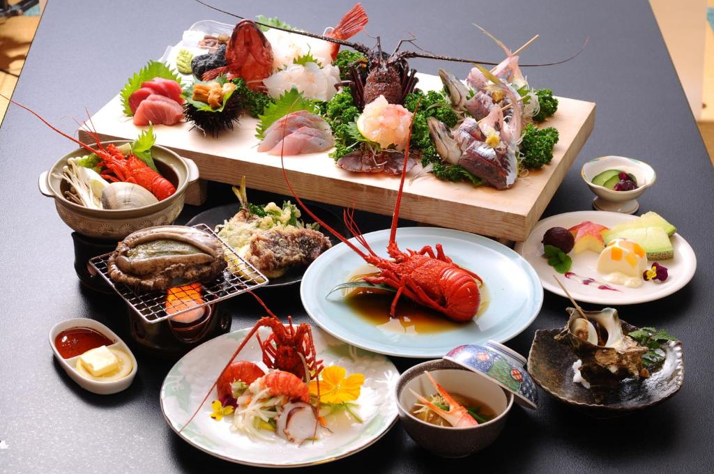 a table with plates of food and bowls of sushi at Seaside Culinary Inn "Masaemon" - Traditional Dinner & Breakfast Included in Minamiboso