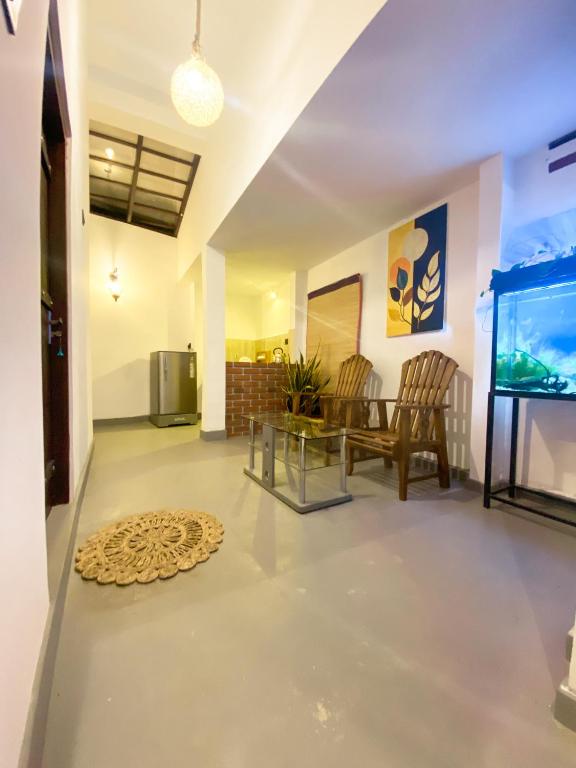 a living room with a table and a fish tank at Greenbliss Hiriketiya in Dickwella