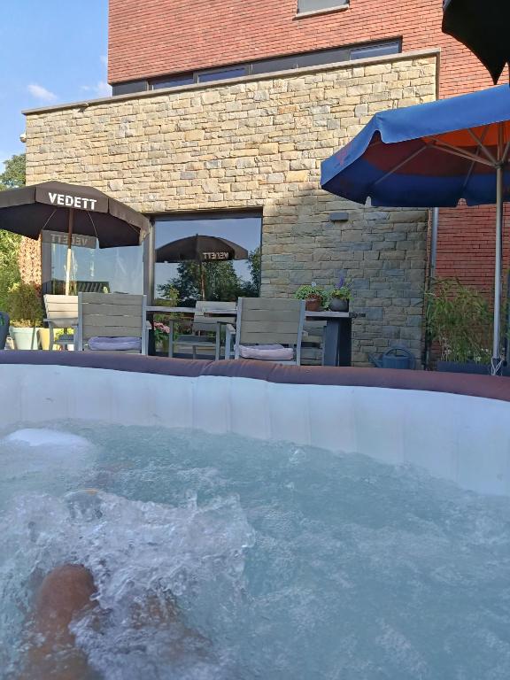 a swimming pool with water and an umbrella at Housedurbuy 1 in Durbuy