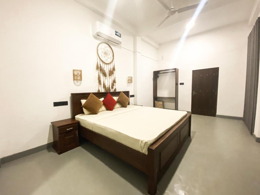 a bedroom with a bed and a clock on the wall at Greenbliss Hiriketiya in Dickwella