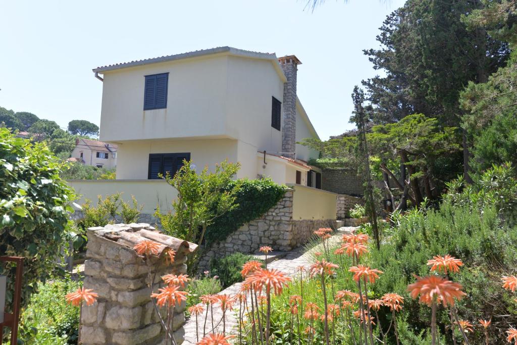 a house on a hill with flowers in front of it at Holiday Home Villa Esperanca in Veli Lošinj