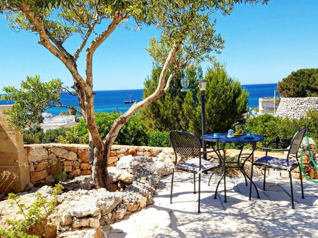 a patio with a table and chairs and a tree at Casa delle sorgenti in Torre Vado