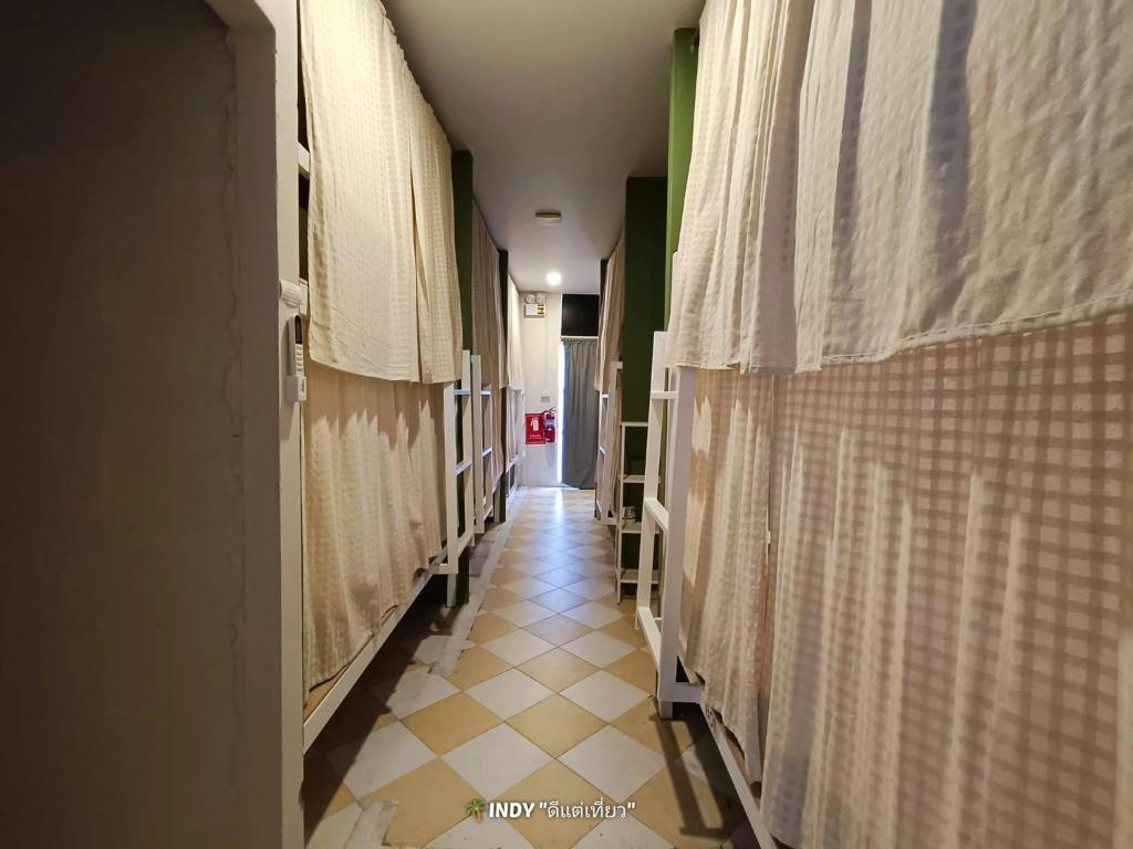 a hallway of a hospital with curtains and a tiled floor at haonornhostel in Ban Madua Wan