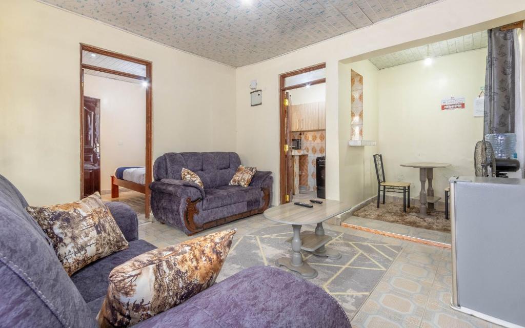 a living room with two couches and a table at Bremu Home - Near jkia airport in Nairobi