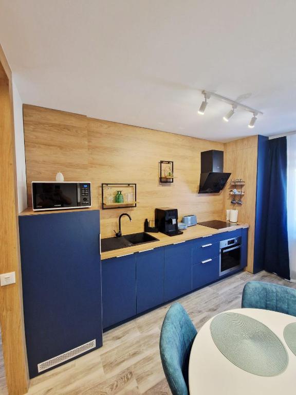 a kitchen with blue cabinets and a sink at SaraHome Turda in Turda