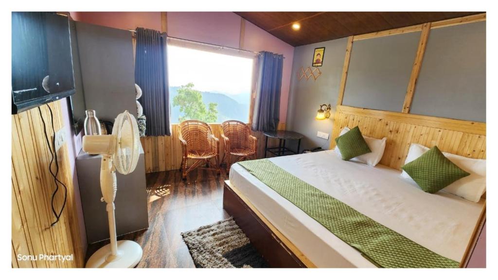 a bedroom with a bed and a large window at Hotel Himaaksh cottages In Sigri in Nainital