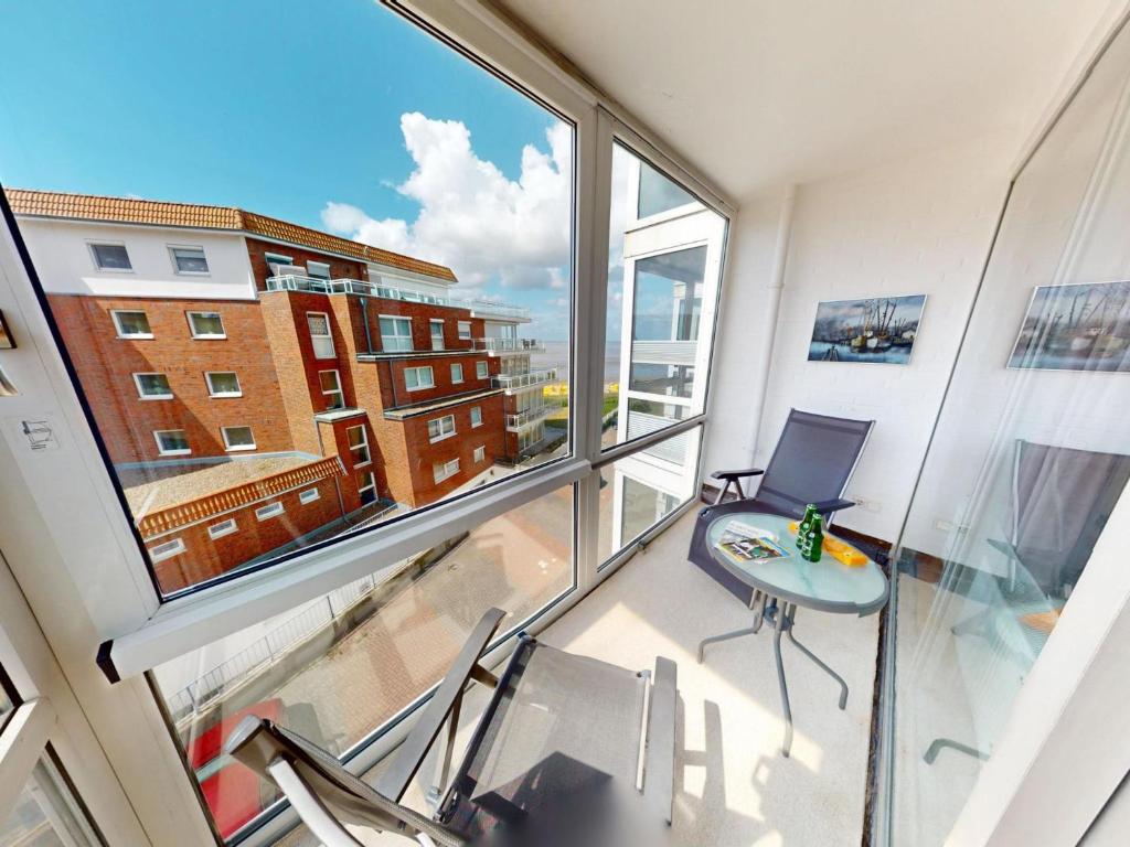 a room with a large window and a table and chairs at Seehütte - 304 in Cuxhaven